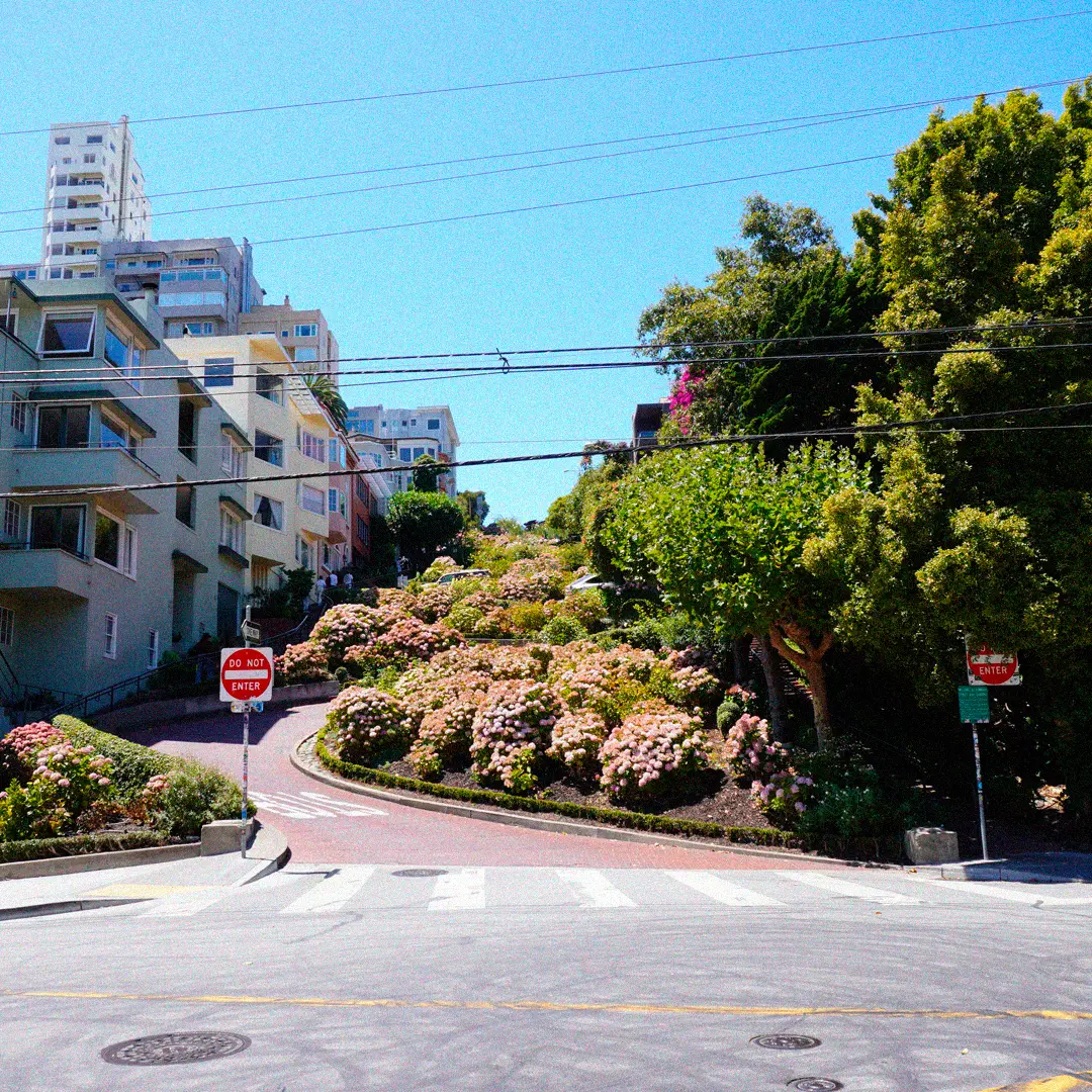 a street with a sign on it with Lombard Street in the background