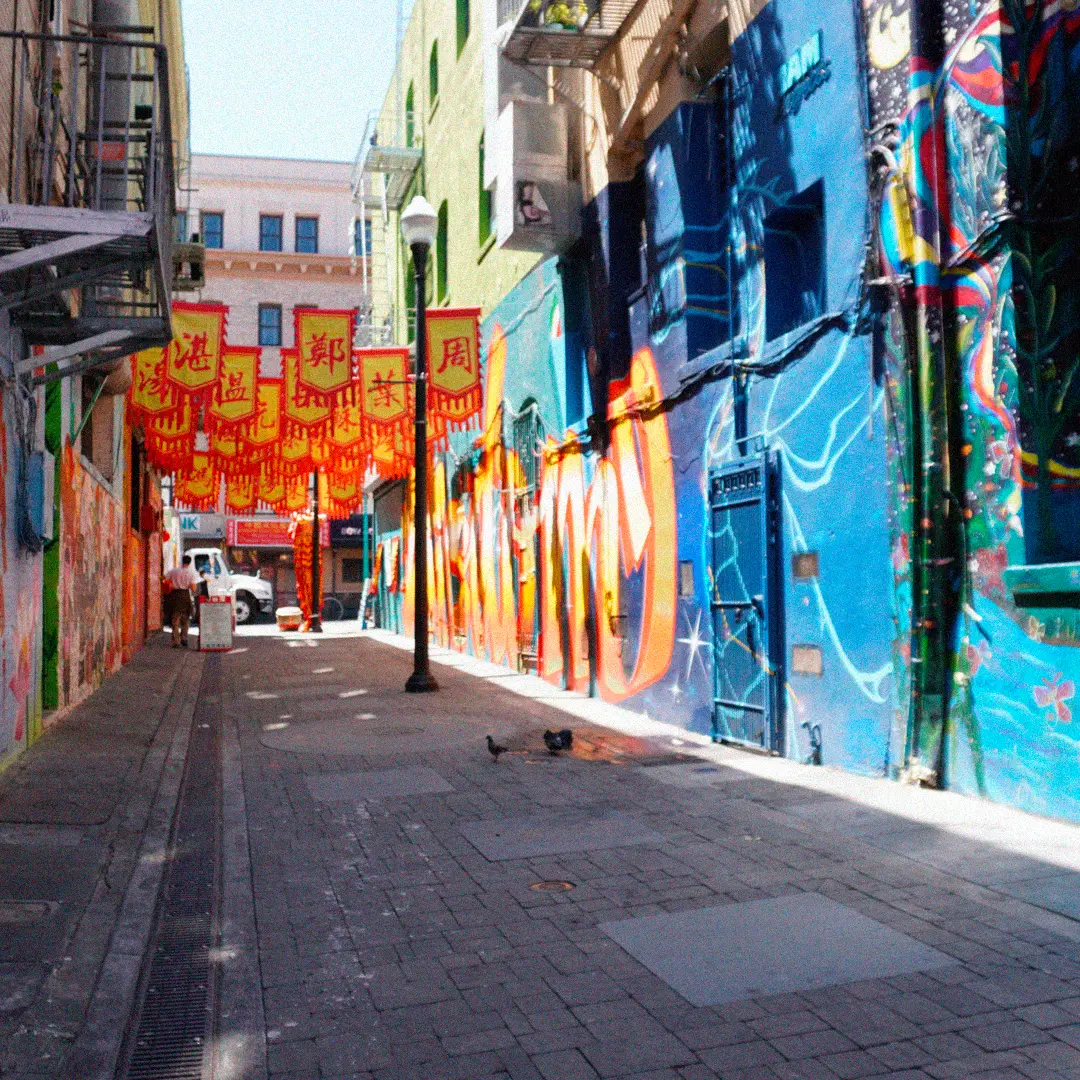 a street with colorful buildings and flags